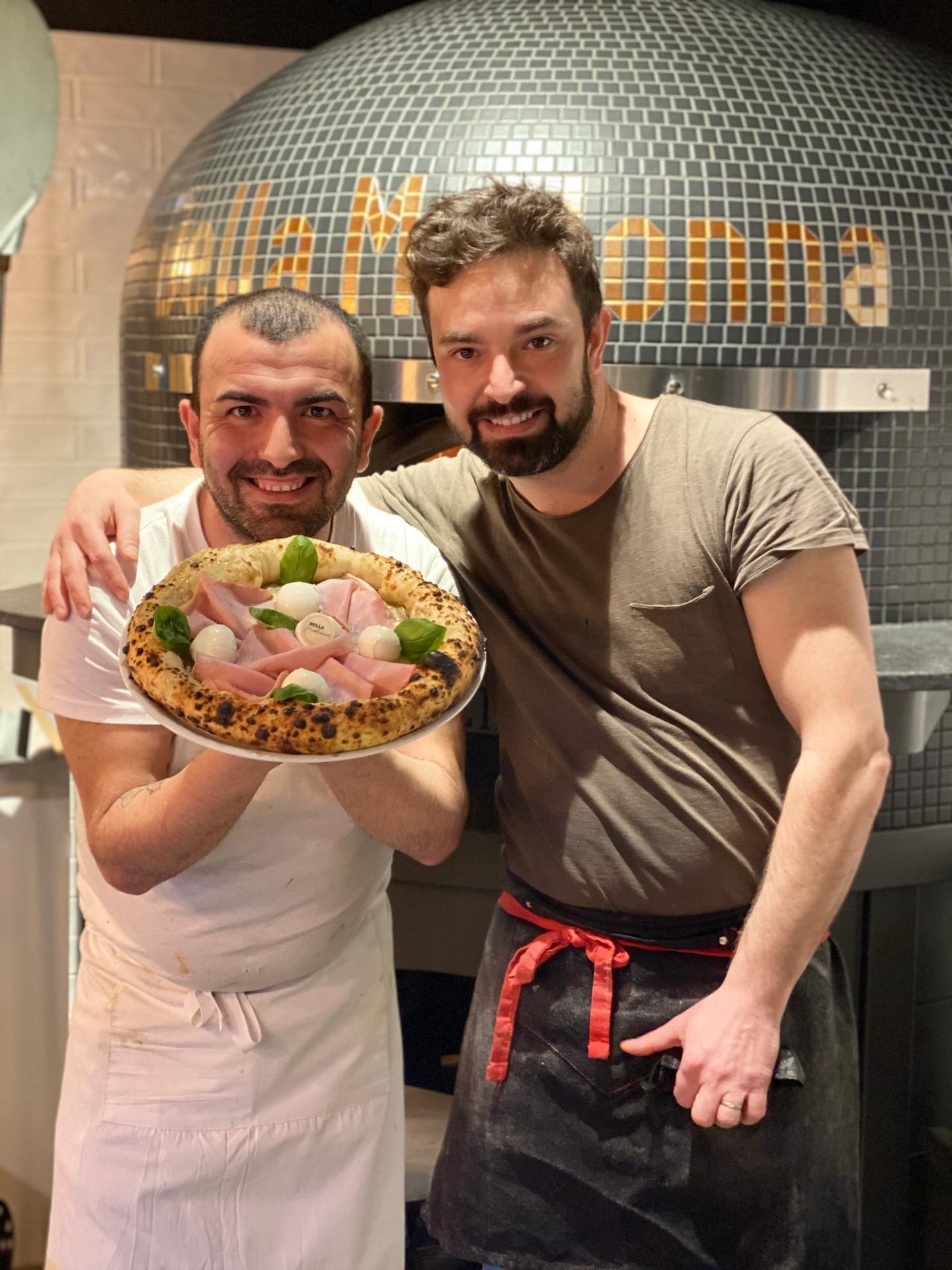 Les pizzaiolos de Della Madonna devant le four à bois avec une pizza