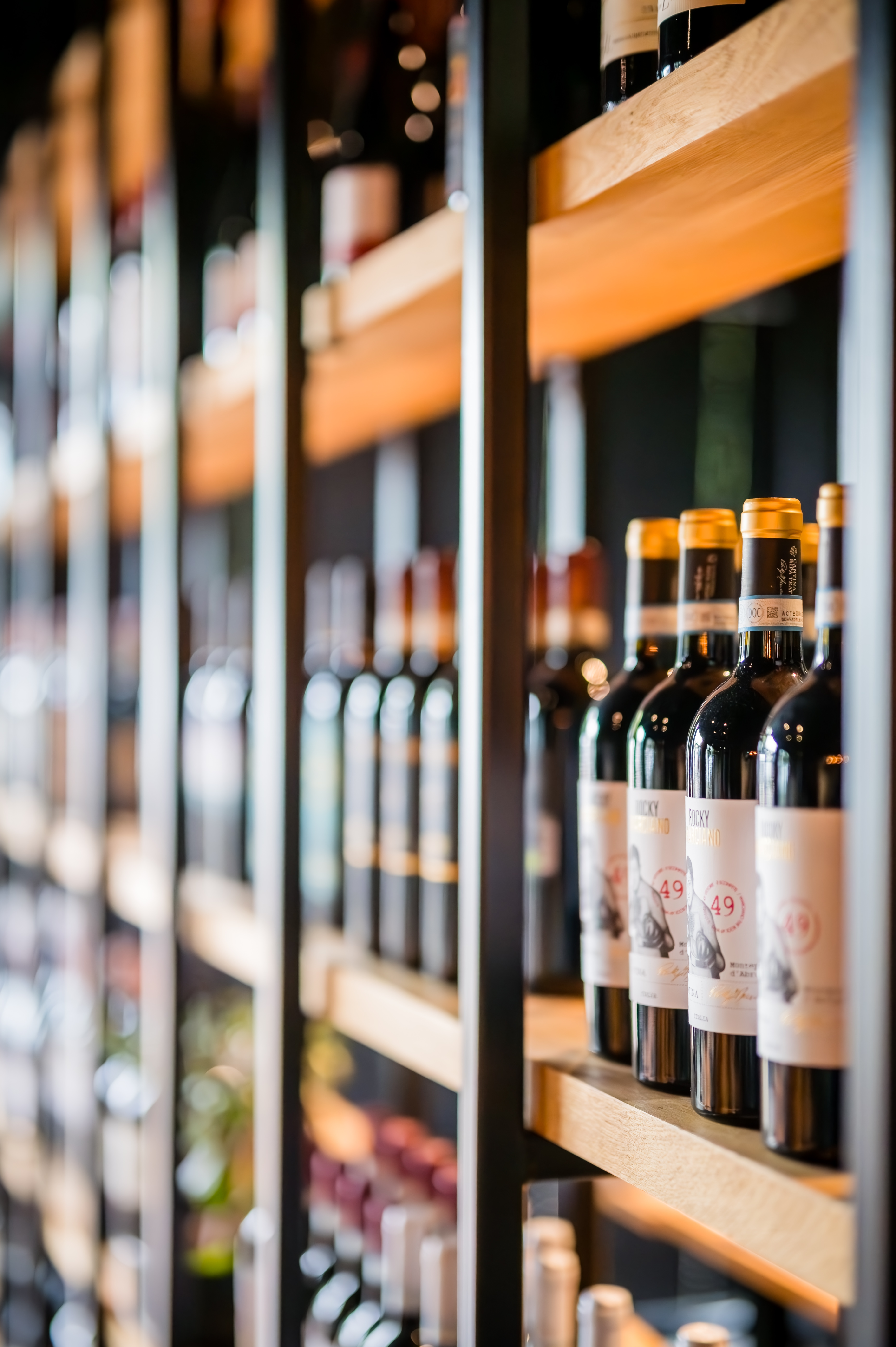 Bouteilles de vins italiens alignées sur les étagères en bois de la cave de Della Madonna